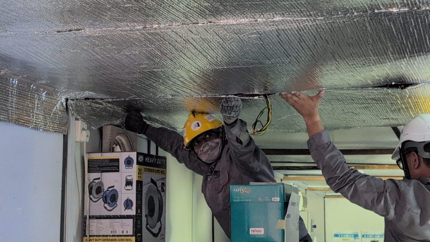 On-site crew fitting reflective sheets to the ceiling