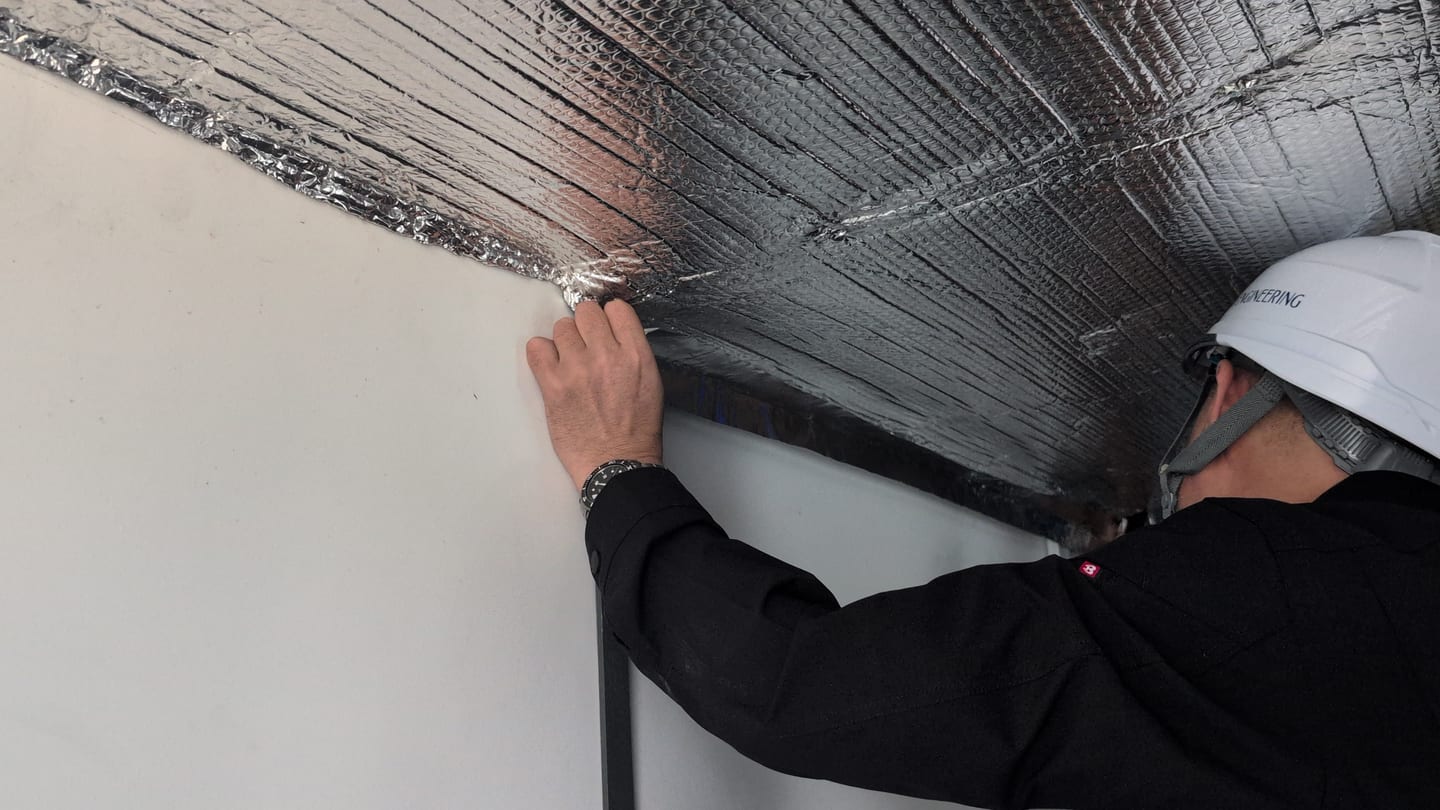 Reflective sheet being fitted at the ceiling and wall junction
